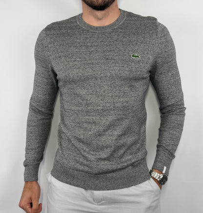 Pull Lacoste gris chiné homme taille XS en très bon état. Pièce seconde main premium sélectionnée par Comptoir Masculin. Expédition rapide depuis la France.